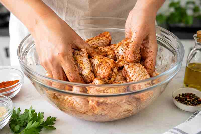Preparing seasoned chicken wings in the kitchen